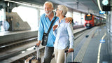 Inogen Rove 6 Portable Oxygen Concentrator old couple at train station carrying the device with the shoulder strap bag. Shop now at Zone Medical.