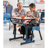 Rifton Compass Chair a child sitting on it with a caregiver. Shop now at Zone Medical.